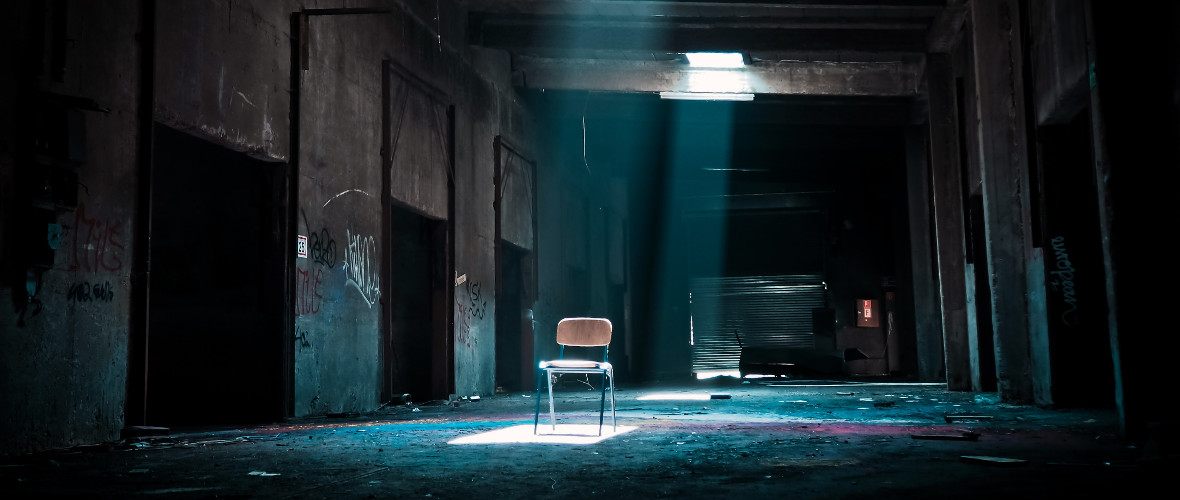 lonely chair in dilapidated warehouse with broken roof