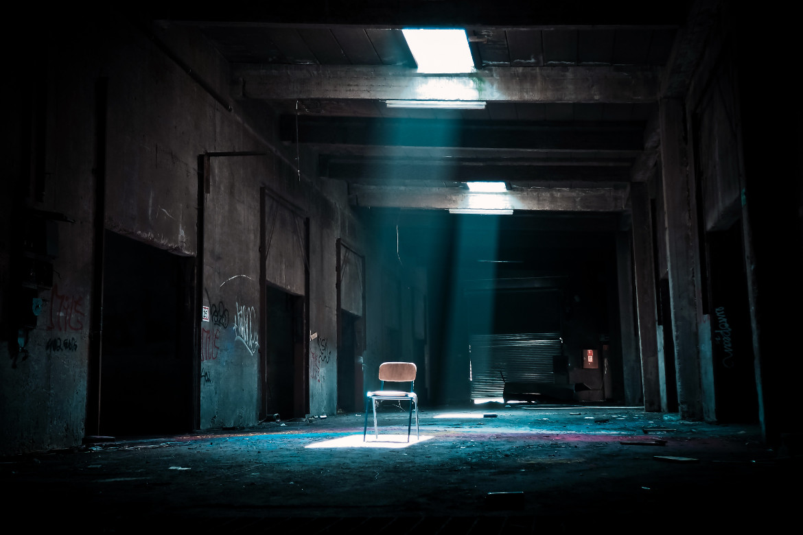 lonely chair in dilapidated warehouse with broken roof